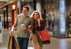 Smiling young couple walking through the mall after some shopping